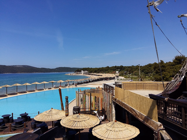 Zwembad met parasols bij het strand van Solaris resort