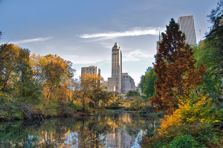 Vijver in Central Park met herfstbomen en wolkenkrabbers