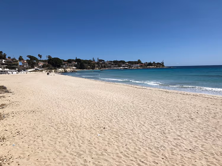 Zandstrand van Fontane Bianche en turquoise zee