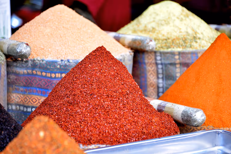 Bir pazarda kırmızı ve sarı baharat yığınları