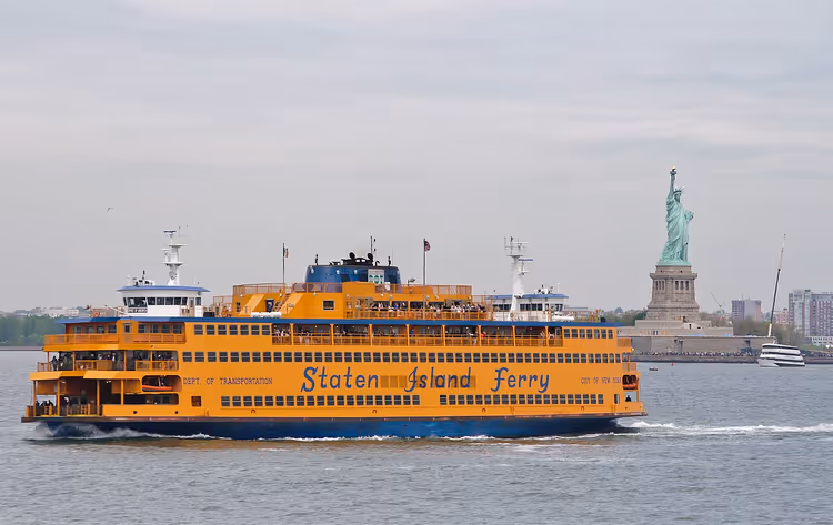 Oranje Staten Island Ferry met het Vrijheidsbeeld op de achtergrond