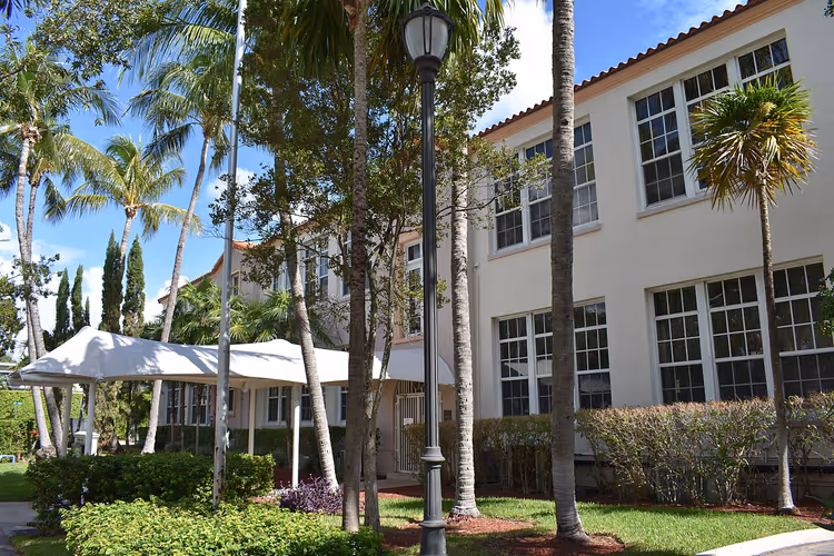 Hvit skolebygning med palmer i Miami Beach
