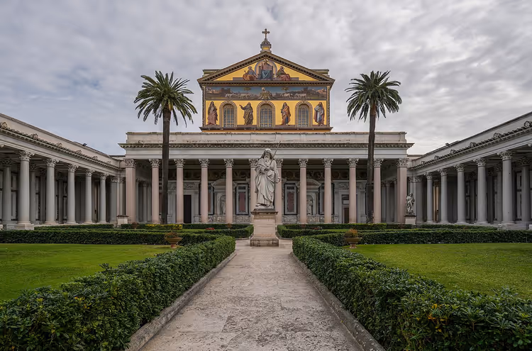 Fasaden til basilikaen San Paolo fuori le Mura med kolonnade og statue