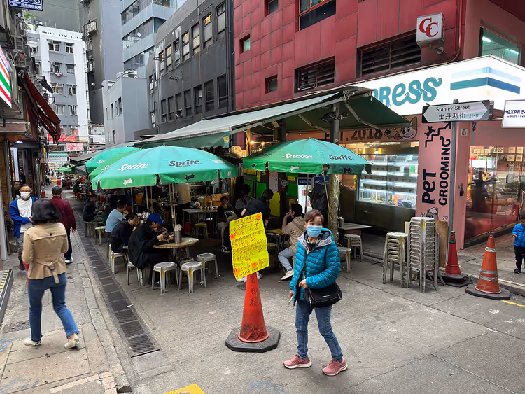 Straatvoedsel in Hong Kong onder groene Sprite-parasols
