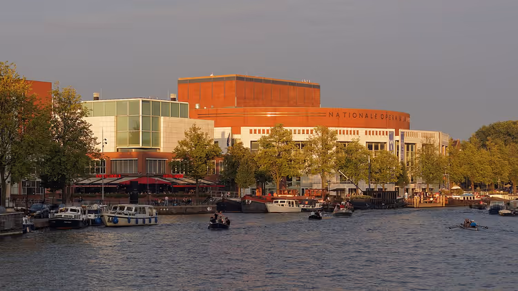 Das Stopera-Gebäude und eine Gracht mit Booten in Amsterdam
