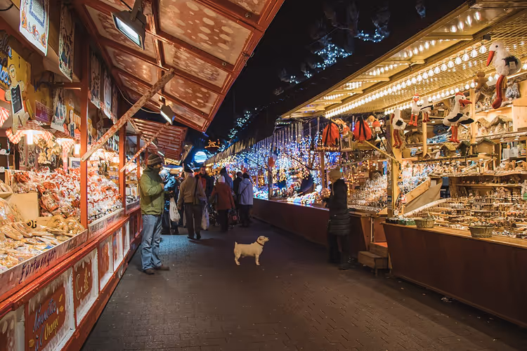 Rijen verlichte kraampjes op de kerstmarkt van Straatsburg in de avond