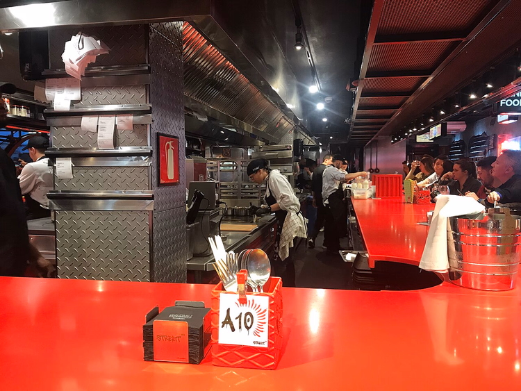 Bancone rosso e cucina a vista di un ristorante