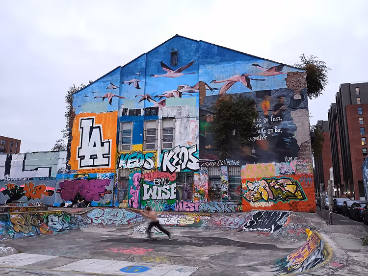 Bygning med veggmalerier og en skatepark med en skater