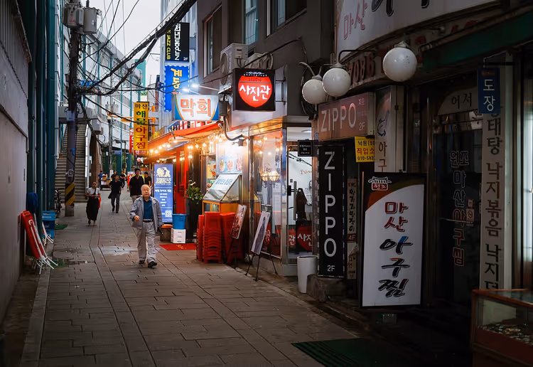 Seoul-gate med koreanske skilt og fotgjengere