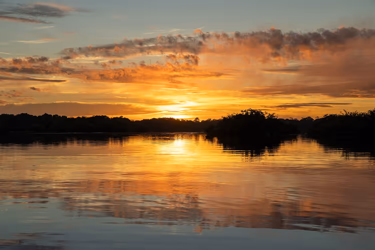 Sonnenuntergang über einem Fluss im Amazonas-Regenwald