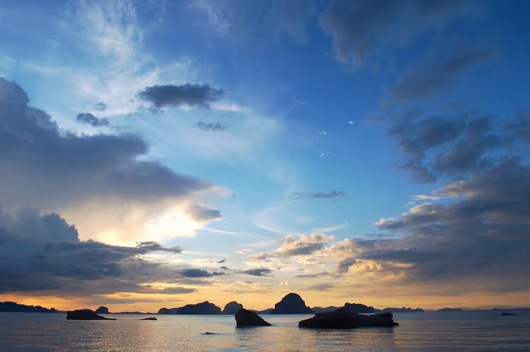 Sonnenuntergang über dem Meer mit Kalksteininseln bei Tubkaek