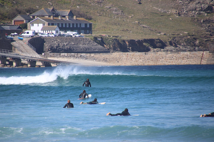Surfer auf den Wellen am Sennen Cove Beach