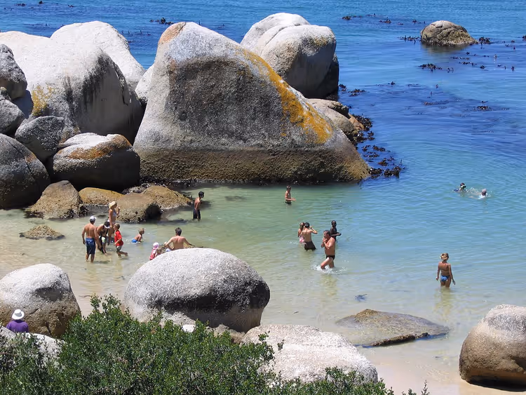 Zwemmers tussen enorme rotsblokken bij Boulders Beach