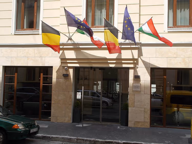Hotelfaçade met vlaggen en glazen entree