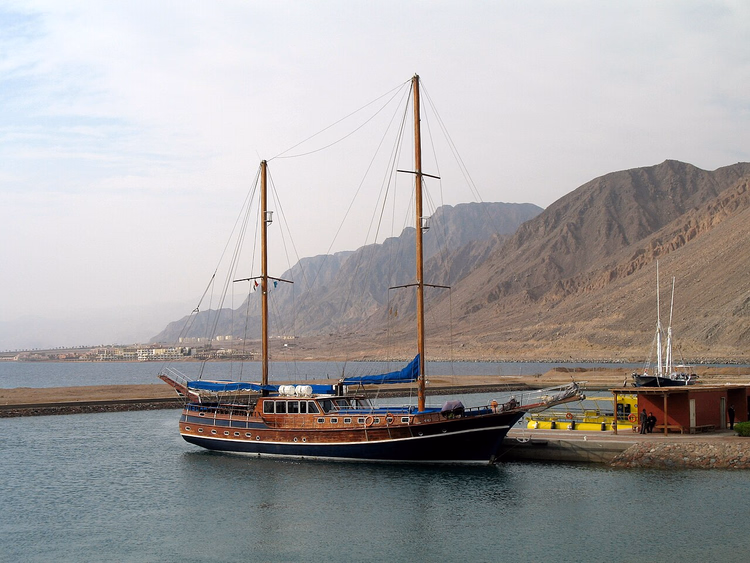 Taba Heights marinada arka planda dağlarla yelkenli