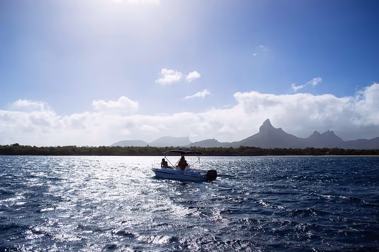 Boot met mensen in een baai tegen vulkanische bergen