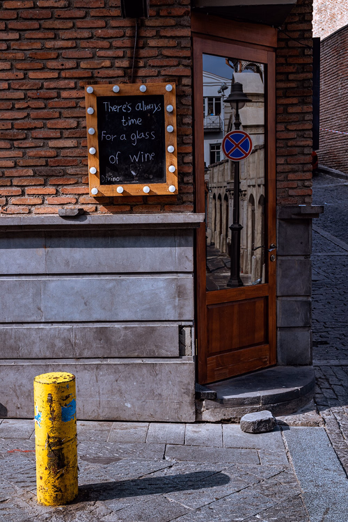 Schild für ein Glas Wein am Eingang einer Bar