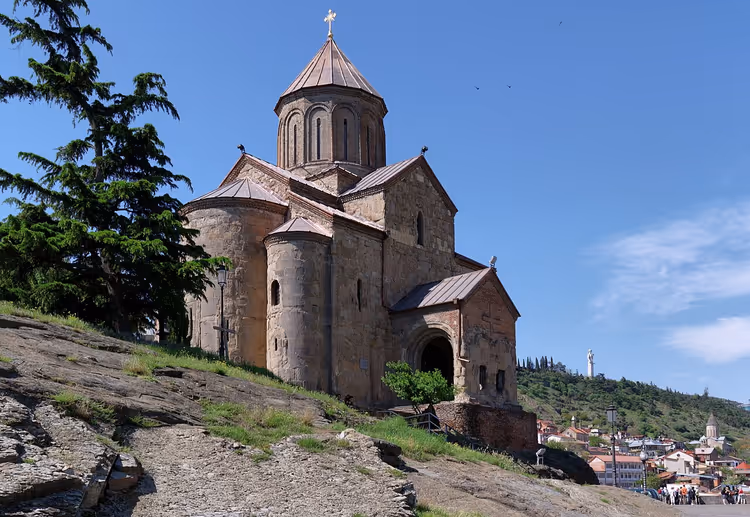 Metekhi-kerk op een rotsachtige heuvel boven Tbilisi