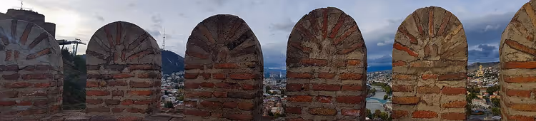 Arched battlements of Narikala fortress wall with Tbilisi in the background