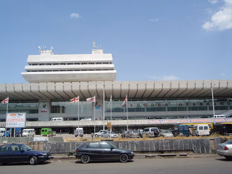 Edificio della stazione ferroviaria di Tbilisi con bandiere georgiane