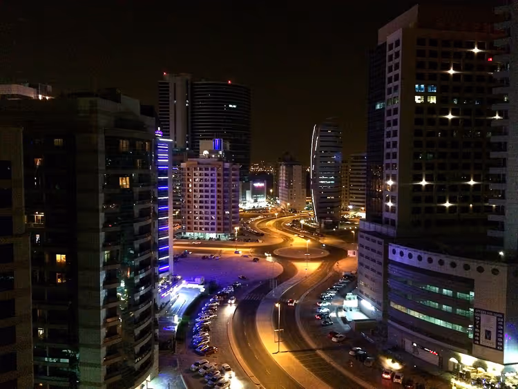 Nachtelijke skyline van de wijk Tecom met hoogbouw en wegen