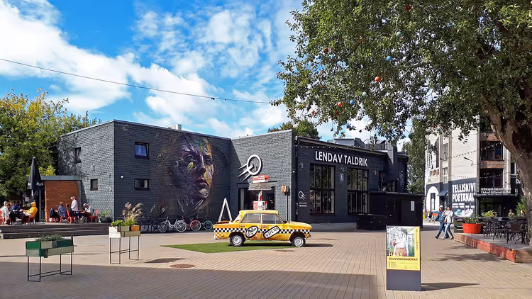 Telliskivi-Hof mit Wandgemälde und gelbem Taxi