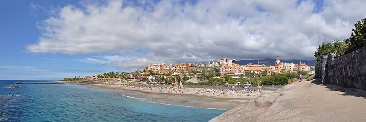 Sandstrand med ferierende og hoteller ved stranden