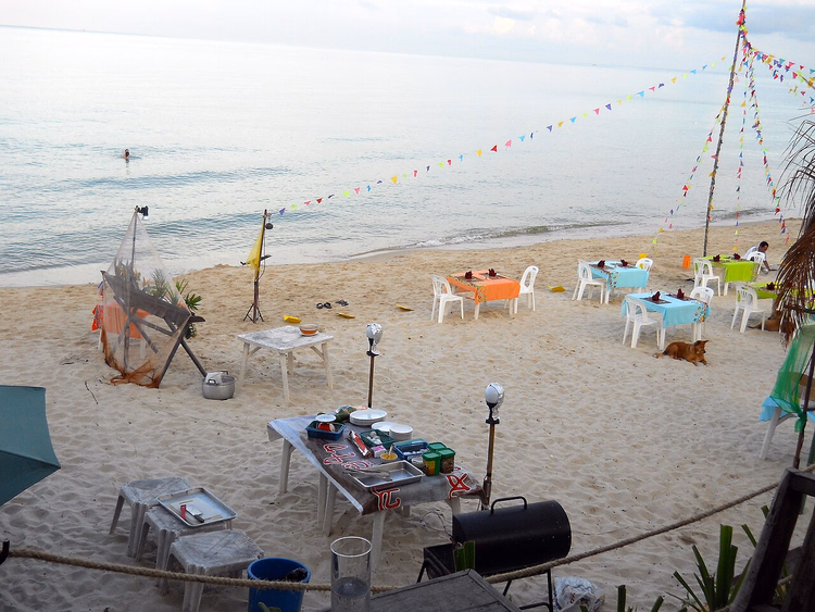 Mesas de restaurante à beira-mar junto ao oceano ao anoitecer