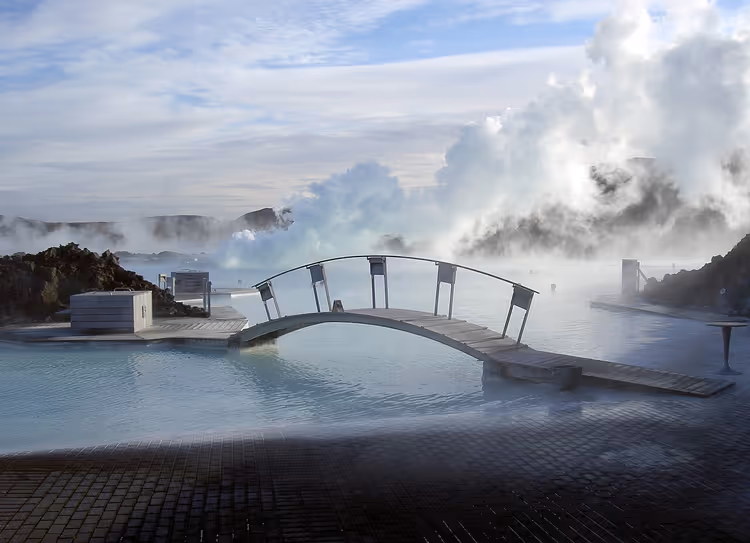 Blue Lagoon'da bir yaya köprüsü ve suyun üzerinde buhar