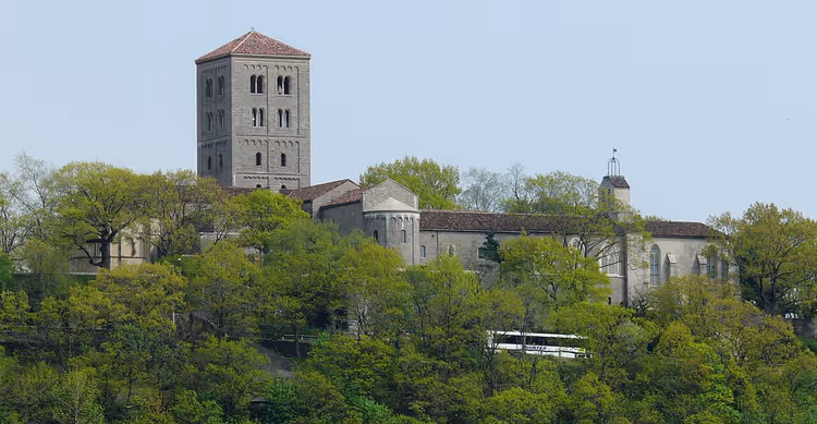 Middelalderbygningen til The Cloisters museum på en skogkledd ås