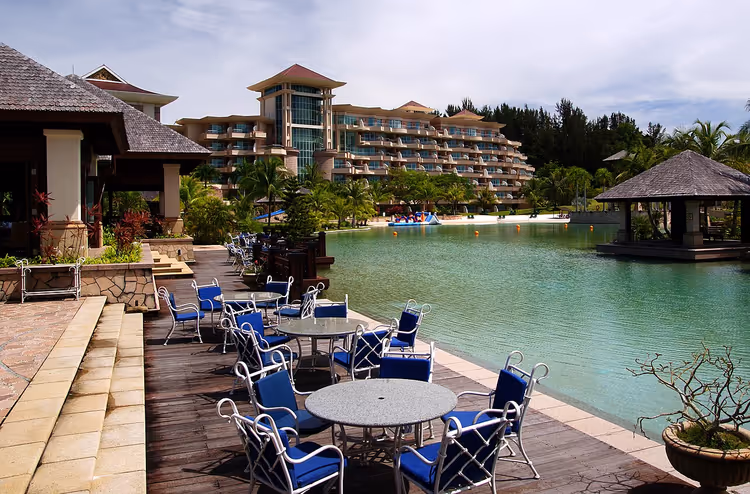 Hotellbassengets terrasse med solsenger og bord
