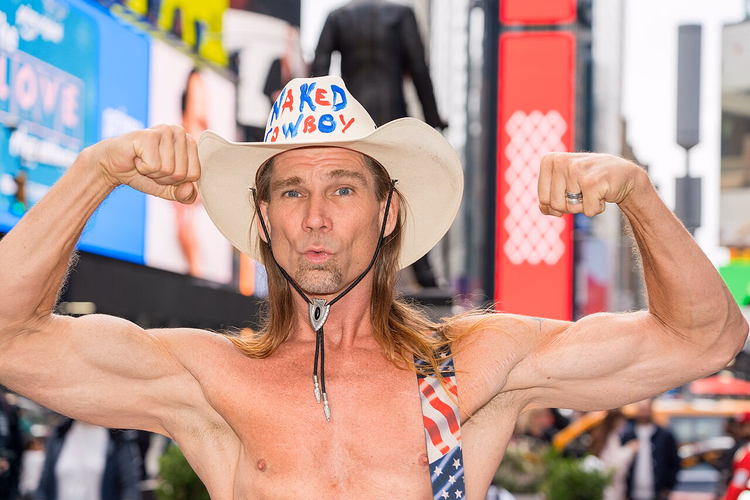 Times Square ekranlarının önünde poz veren Naked Cowboy