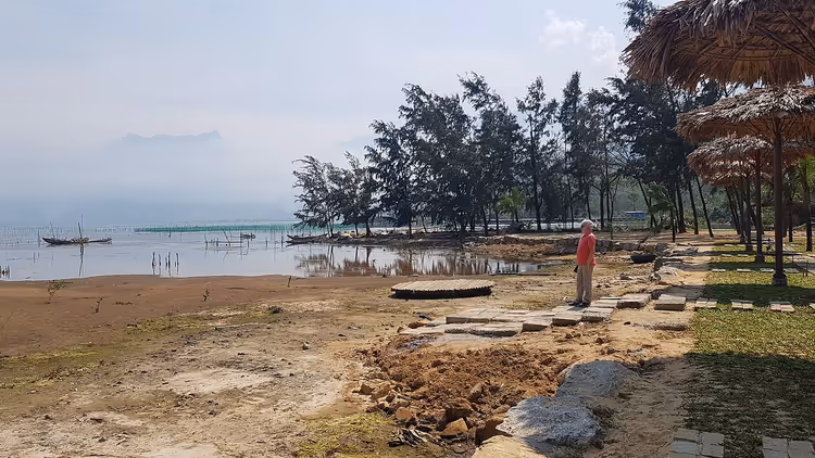Man bij een lagune met bomen in Vietnam