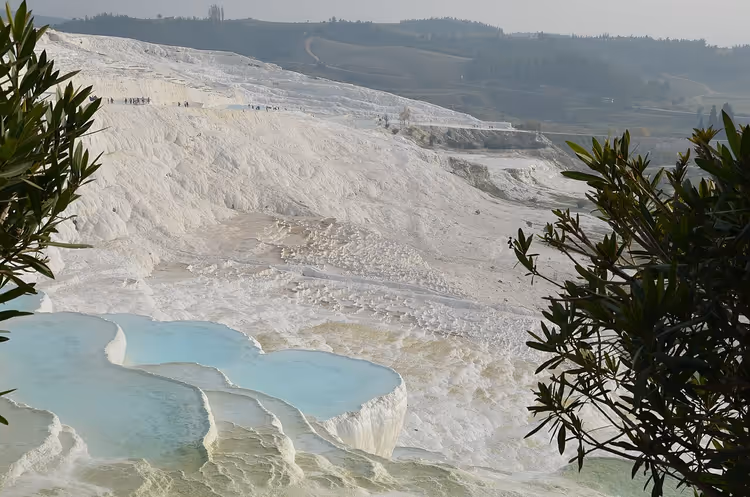 White travertine terraces of Pamukkale with blue water