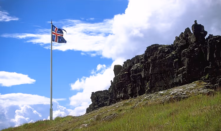 Thingvellir'de kayalık bir uçurumun yanında İzlanda bayrağı