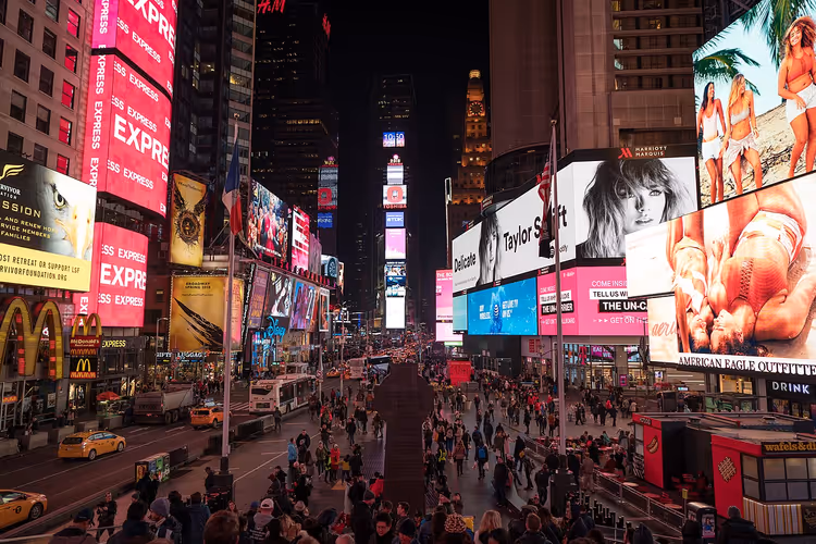 Times Square bei Nacht mit Leuchtreklamen und Menschenmengen