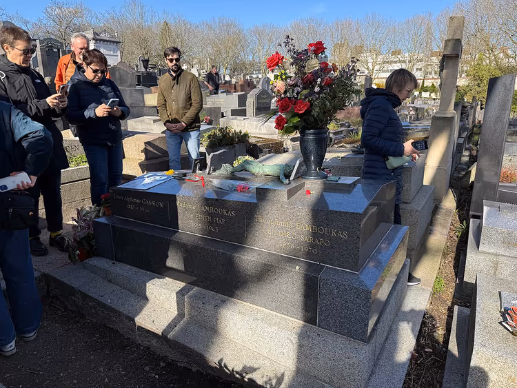 Graf met rode rozen en bezoekers op de begraafplaats Père Lachaise
