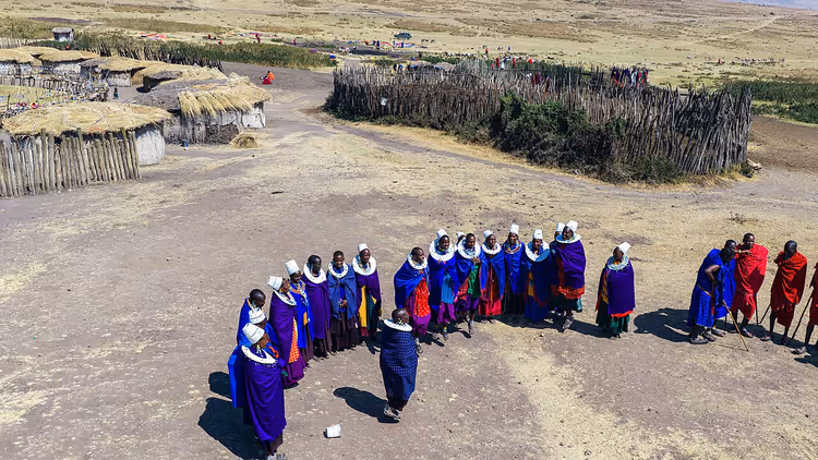Maasai-folk samlet i tradisjonelle klær i en landsby