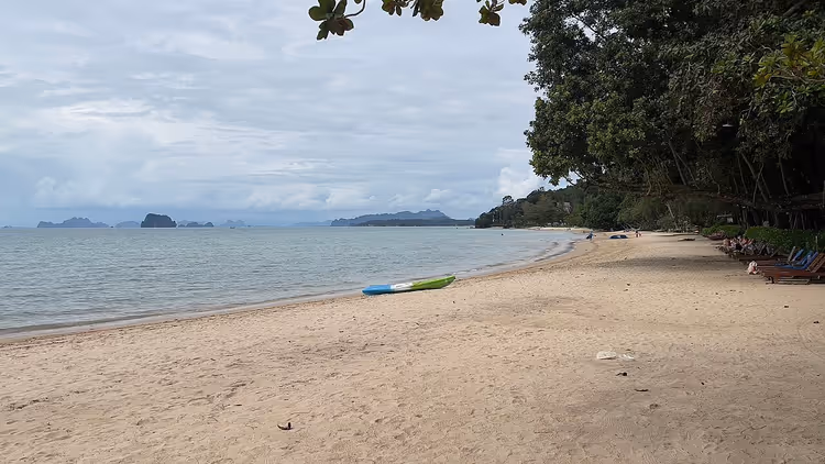 Strand mit Kajak und Liegen am Meer