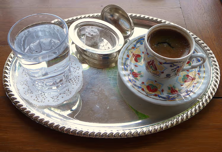 Tasse türkischen Kaffees auf einem Tablett mit einem Glas Wasser