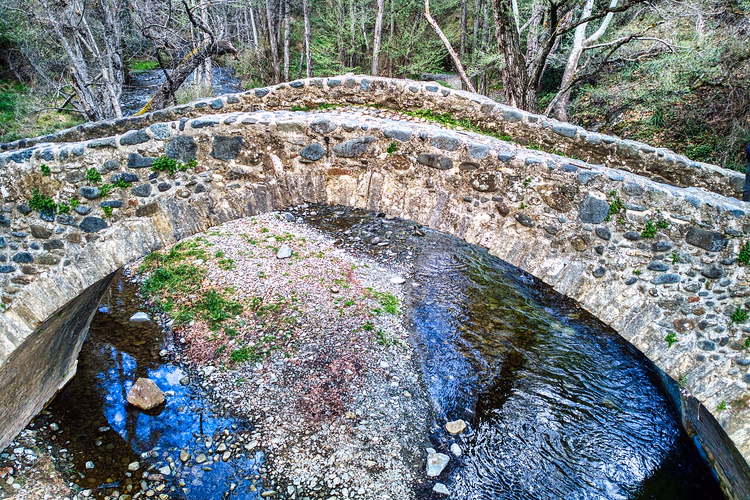Steinbogenbrücke von Tzelefos über einem Waldbach