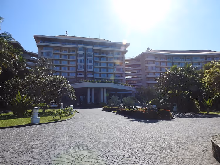 Gevel van het Taj Samudra hotel met oprit en bomen