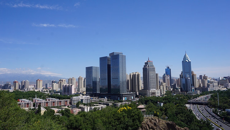 Wolkenkratzer der Innenstadt von Urumqi vor den Bergen