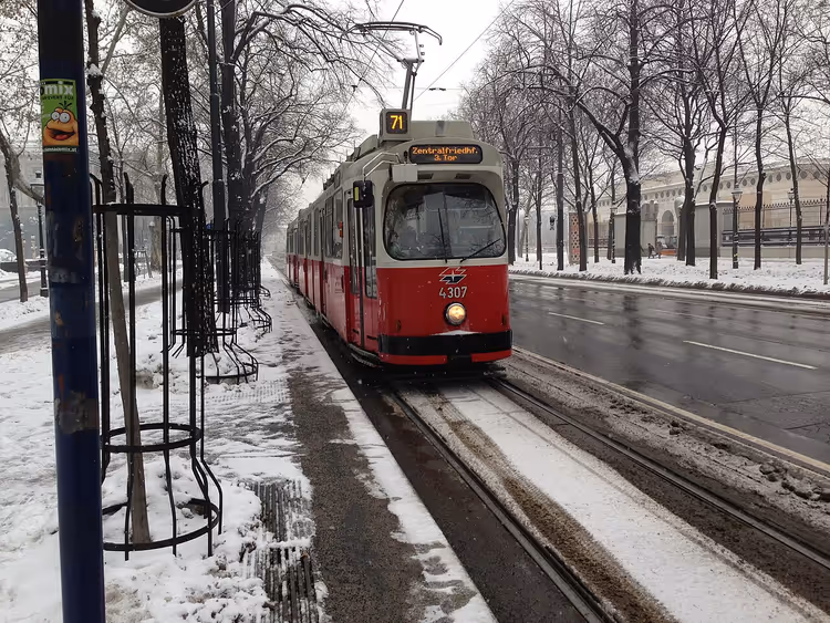 Rød trikk i snødekte Ringstrasse i Wien