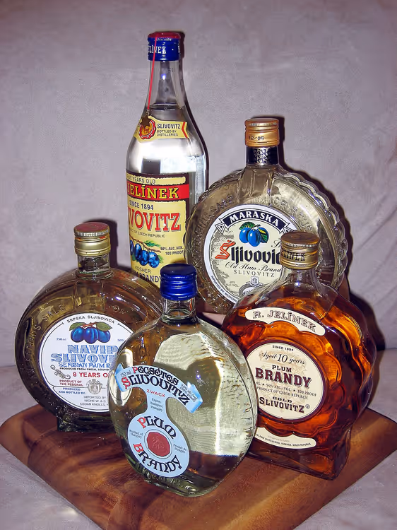Flessen slivovitz en pruimenbrandewijn op een plank
