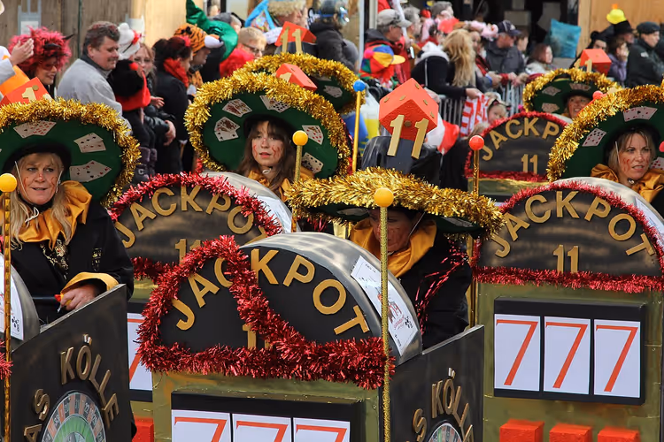 Teilnehmer des Veedelszoch-Karnevalsumzugs auf einem Festwagen mit dem Schriftzug Jackpot