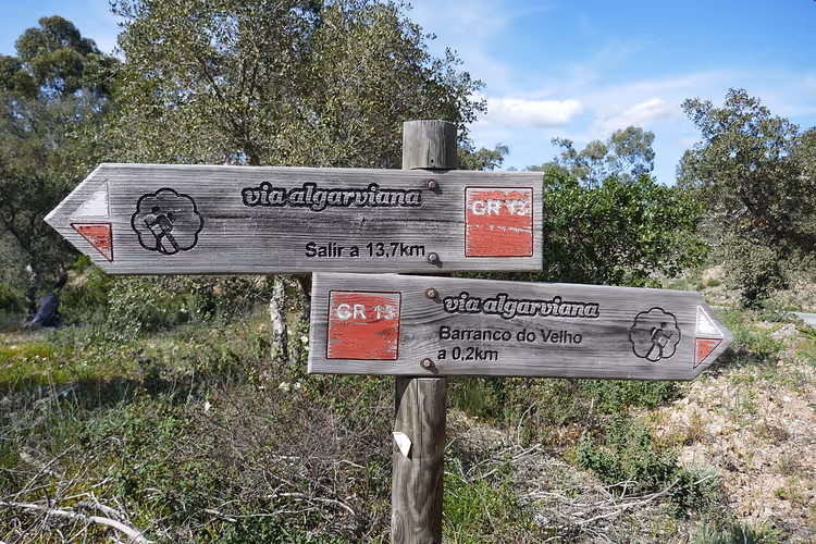 Hölzernes Via-Algarviana-GR13-Wegzeichen im Wald