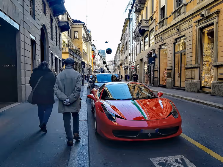Красный Ferrari на улице люксовых бутиков