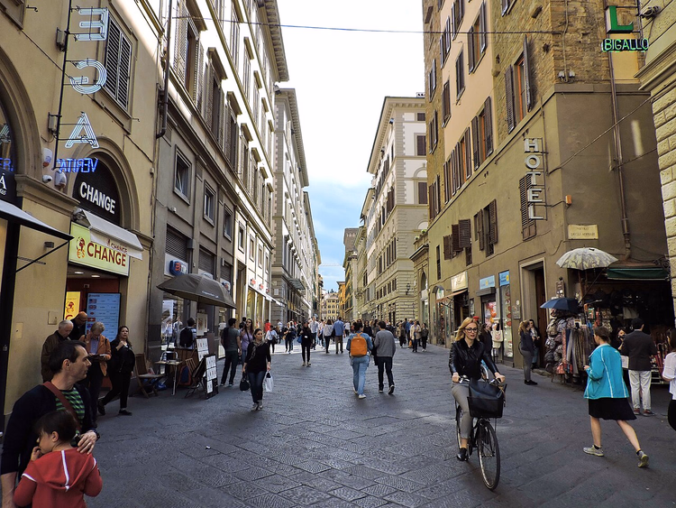 Voetgangersgebied Via dei Calzaiuoli met voorbijgangers en een fietser