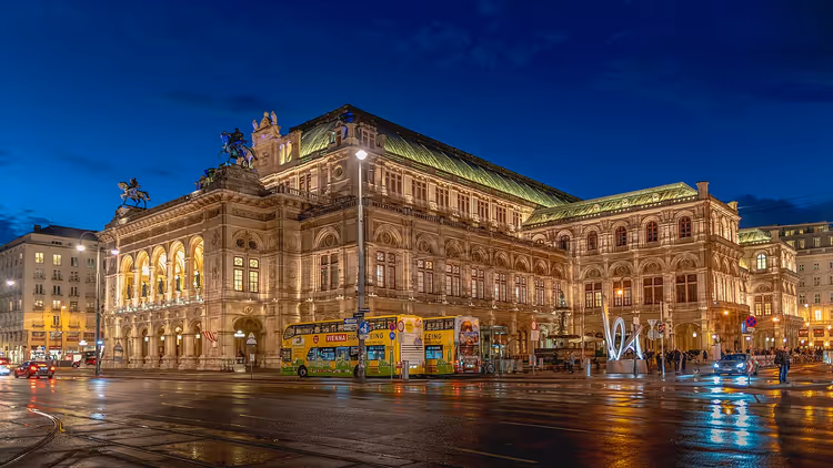 Wiener Staatsoper bei Nacht mit beleuchteter Fassade